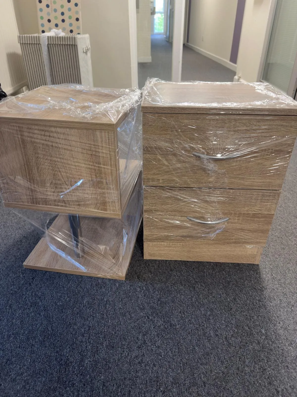Stacked moving boxes in a hallway with a notepad and pen on top