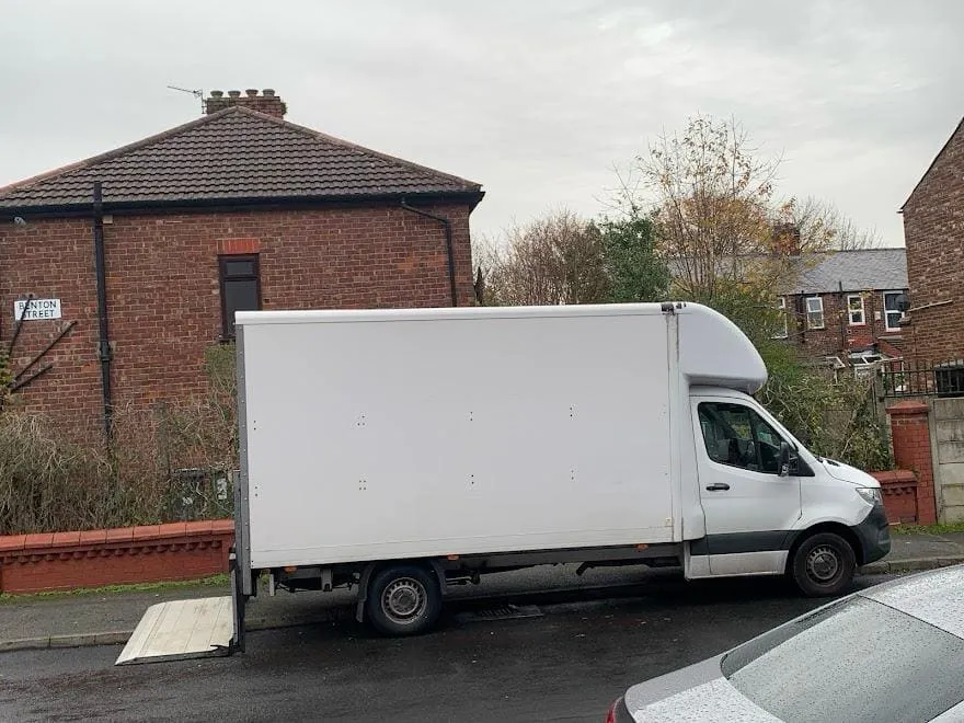 Luton box van being loaded with boxes on a cobbled street